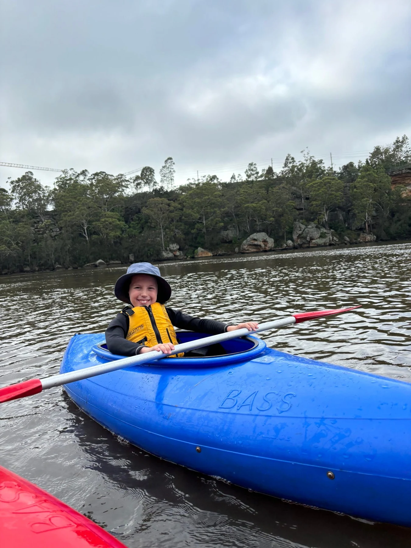 A child paddling a blue kayak on the water.